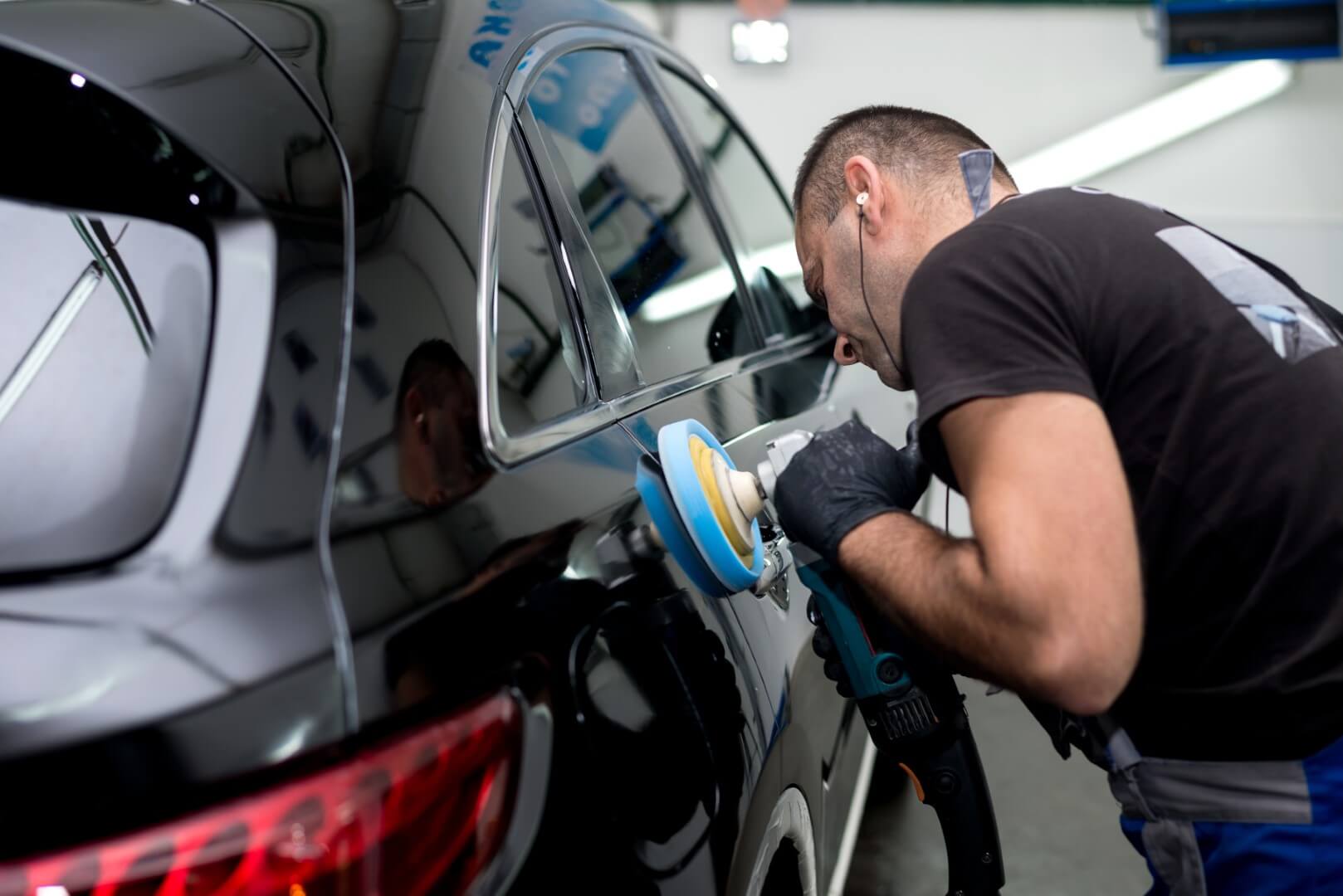 Car detailing expert from Bradford waxing a car.